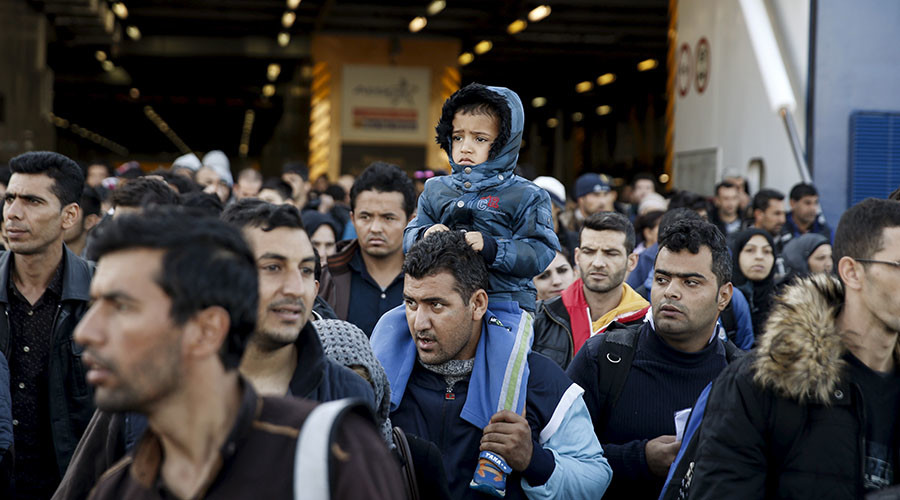 Refugees and migrants arrive aboard the passenger ferry Blue Star Patmos from the islands of Lesbos and Chios, at the port of Piraeus, near Athens, Greece, October 25, 2015. Over half a million refugees and migrants have arrived by sea in Greece this year and the rate of arrivals is rising, in a rush to beat the onset of freezing winter, the United Nations said. REUTERS/Alkis Konstantinidis - RTX1T3Y9
